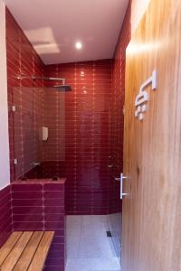 a bathroom with a shower with red tiles at Maya Papaya in Antigua Guatemala