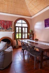 a dining room with a table and a fireplace at Maya Papaya in Antigua Guatemala