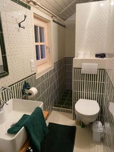 ein Bad mit einem Waschbecken und einem WC in der Unterkunft Csörgő Vendégházak in Szalafő