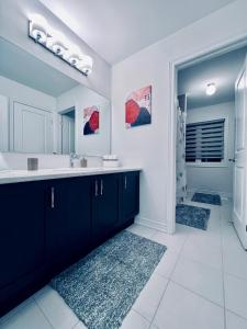 uma casa de banho com um lavatório e um espelho em Brand New! Modern Luxury Retreat! em Barrie