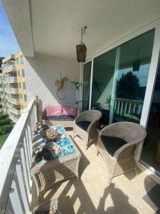 a patio with a table and chairs on a balcony at Condominio Bahia Pelicanos - Horcon in Puchuncaví