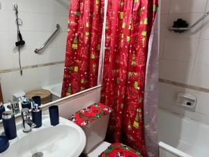a bathroom with a red shower curtain and a sink at Condominio Bahia Pelicanos - Horcon in Puchuncaví
