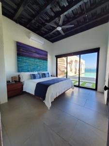 CASA ROMA Hotel Boutique في El Tamarindo: غرفة نوم مع سرير وإطلالة على المحيط