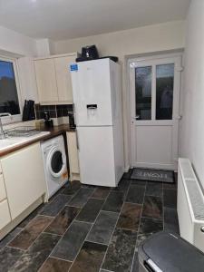 eine Küche mit einem Kühlschrank und einer Waschmaschine in der Unterkunft 3 bedroom detached house centre of Whitchurch in Whitchurch