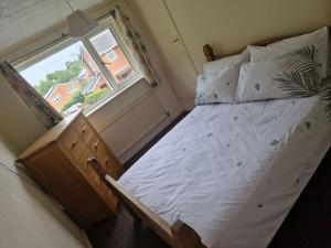 ein großes Bett in einem Schlafzimmer mit Fenster in der Unterkunft 3 bedroom detached house centre of Whitchurch in Whitchurch