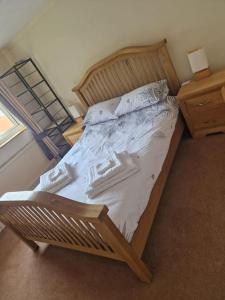 ein großes Bett in einem Schlafzimmer mit einem Holzrahmen in der Unterkunft 3 bedroom detached house centre of Whitchurch in Whitchurch