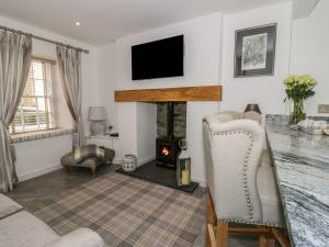 a living room with a fireplace and a tv at 9 Chapel Street in Conwy