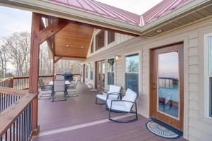 a porch with white chairs and a roof at Spacious Harrison Vacation Rental with Deck and Views! in Harrison