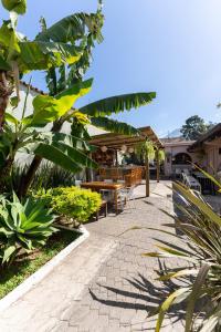 a patio with tables and chairs and plants at Maya Papaya in Antigua Guatemala