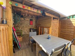 a patio with a table and chairs on a deck at Yport, maison de pêcheur avec jolie terrasse. in Yport +31 photos