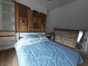 a bedroom with a large bed with blue sheets at Yport, maison de pêcheur avec jolie terrasse. in Yport