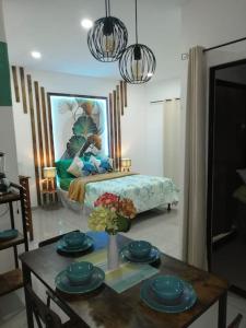 a living room with a table and a bed at Cabañas Mantas in Jacó