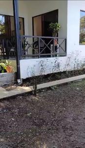 a house with a balcony with a plant on it at Cabañas Mantas in Jacó