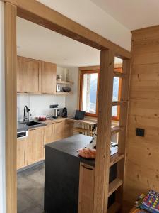 a kitchen with wooden cabinets and a black counter top at Les Mélèzes, joli duplex dans un chalet in Montvalezan