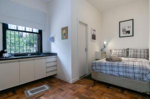 a bedroom with a bed and a sink and a window at Studios do Vale 1 in Sao Paulo