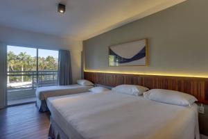 a hotel room with two beds and a window at Hotel Porto Sol Beach in Florianópolis +64 photos