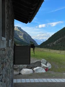 un edificio de piedra con un cartel en el costado en LA RÊVERIE DE THUMEL - CHAMBRES en Rhêmes-Notre-Dame