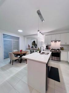 a kitchen with white cabinets and a table in it at Brand New! Modern Luxury Retreat! in Barrie