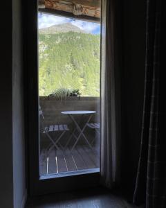 Zimmer mit einem Fenster mit einem Tisch und Aussicht in der Unterkunft LA RÊVERIE DE THUMEL - CHAMBRES in Rhêmes-Notre-Dame