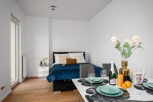 Un dormitorio con una cama y una mesa con platos. en Warsaw Apartments Bliska Wola, en Varsovia