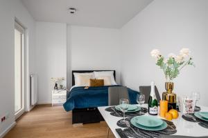 a bedroom with a bed and a table with plates on it at Warsaw Apartments Bliska Wola in Warsaw