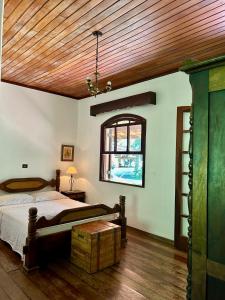 1 dormitorio con cama y techo de madera en Sítio Mato Dentro en Atibaia