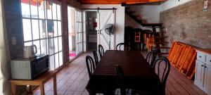 uma sala de jantar com mesa, cadeiras e janelas em De leon em Rosário