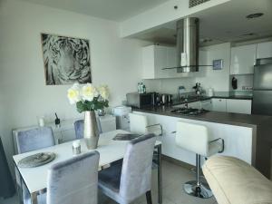 a kitchen with a table with a vase of flowers on it at Sea View 1BR Al Raha Beach in Abu Dhabi