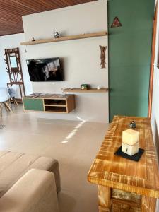 ein Wohnzimmer mit einem Tisch und einem TV in der Unterkunft Karin’s Haus in Treze Tílias