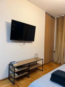 a flat screen tv hanging on a wall in a bedroom at LP Premium Studio in Niš