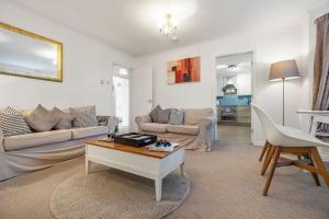 a living room with a couch and a table at Spacious Apartment with Parking! in Jesmond
