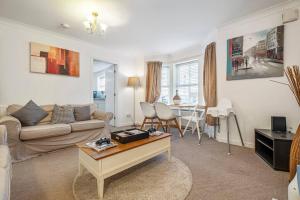 a living room with a couch and a table at Spacious Apartment with Parking! in Jesmond
