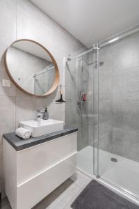 a bathroom with a sink and a shower with a mirror at Classy & Cozy apartment 2 in Ljubljana
