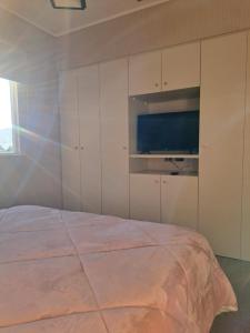 a bedroom with a bed and a flat screen tv at House Patagonia II in Coihaique