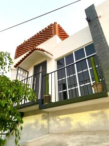 uma casa branca com uma varanda preta em Casa Onésima. Departamento privado con Terraza. em Oaxaca de Juárez