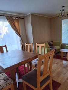 a living room with a wooden table and chairs at House Patagonia II in Coihaique