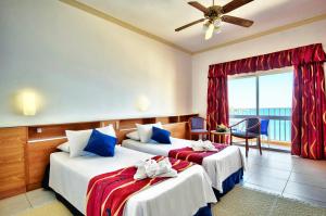 a hotel room with two beds and a balcony at Paradise Bay Resort in Mellieħa