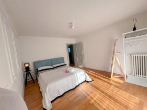 a white bedroom with a bed and a wooden floor at Suite Room in shared apartment with Mt Rigi View in Goldau