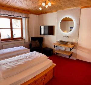 a bedroom with a bed and a desk and a mirror at Haus Plattenkar in Obertauern