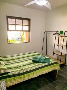 ein Bett in einem Zimmer mit Fenster in der Unterkunft Casa Pedra & Mar - Paraiso na Praia de Caieiras in Guaratuba