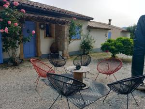 a group of chairs and a table in front of a house at GÎTE LA MOUNTAGNA in Peyroules