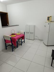 una cocina con mesa roja, sillas y electrodomésticos en Apartamento Quarto e Cozinha cod 4 Tremembe, en São Paulo
