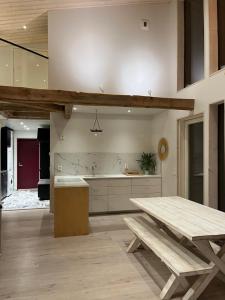 a kitchen with a wooden table and a bench at Villa Hekuma in Keränen