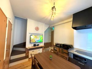 a living room with a table and a flat screen tv at VILLENT Tsukamoto - Vacation STAY 15882 in Osaka