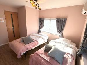 a room with two beds and a window at VILLENT Tsukamoto - Vacation STAY 15882 in Osaka
