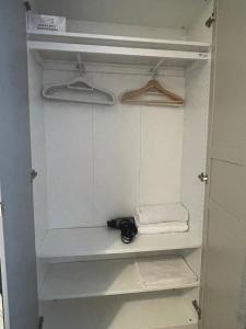 an empty closet with a pair of hangers at Harlesden House in London