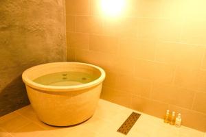 La salle de bains d'angle est pourvue d'une grande baignoire. dans l'établissement The Bath & Bed Obuse - Vacation STAY 15924, à Obuse