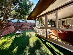 uma casa com um quintal com uma árvore e uma janela em NEW Beautiful San Diego Mid-Century Treehouse em Spring Valley