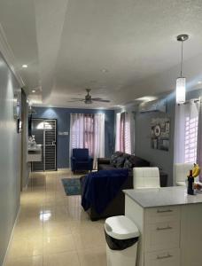 a kitchen and living room with a couch and a table at The Cameron @ Phoenix Park in Portmore