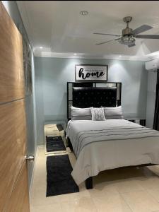 a bedroom with a bed with a sign that reads home at The Cameron @ Phoenix Park in Portmore